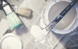 white paint bucket and paint brush