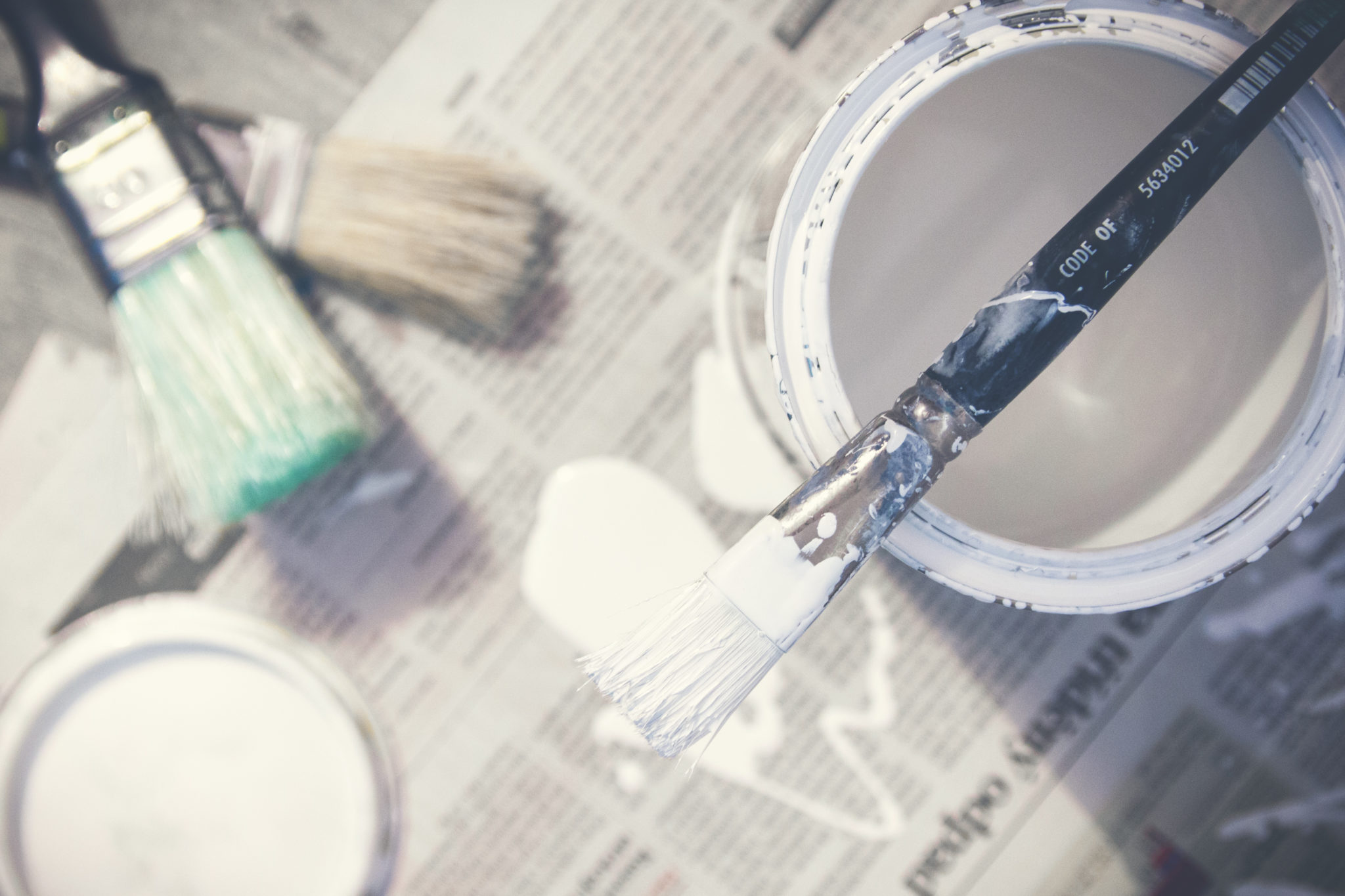 white paint bucket and paint brush