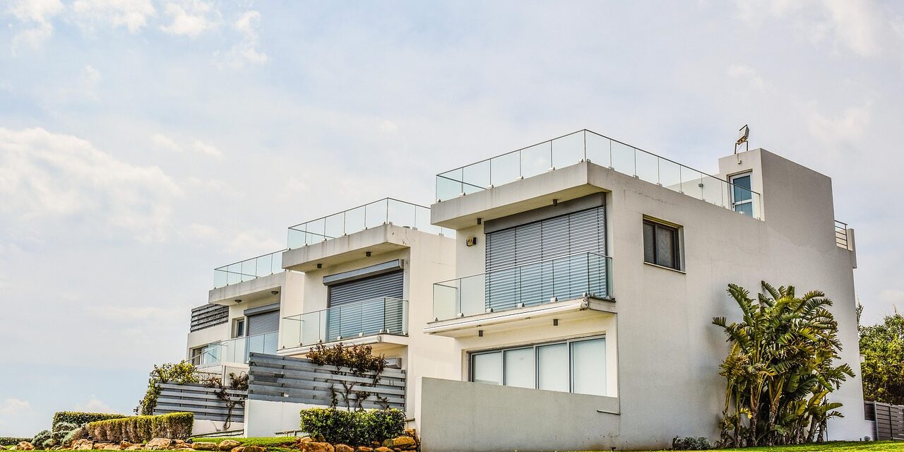 commercial exterior painting Modern white houses with glass balconies and lush green lawn, exuding a sleek and serene outdoor vibe.