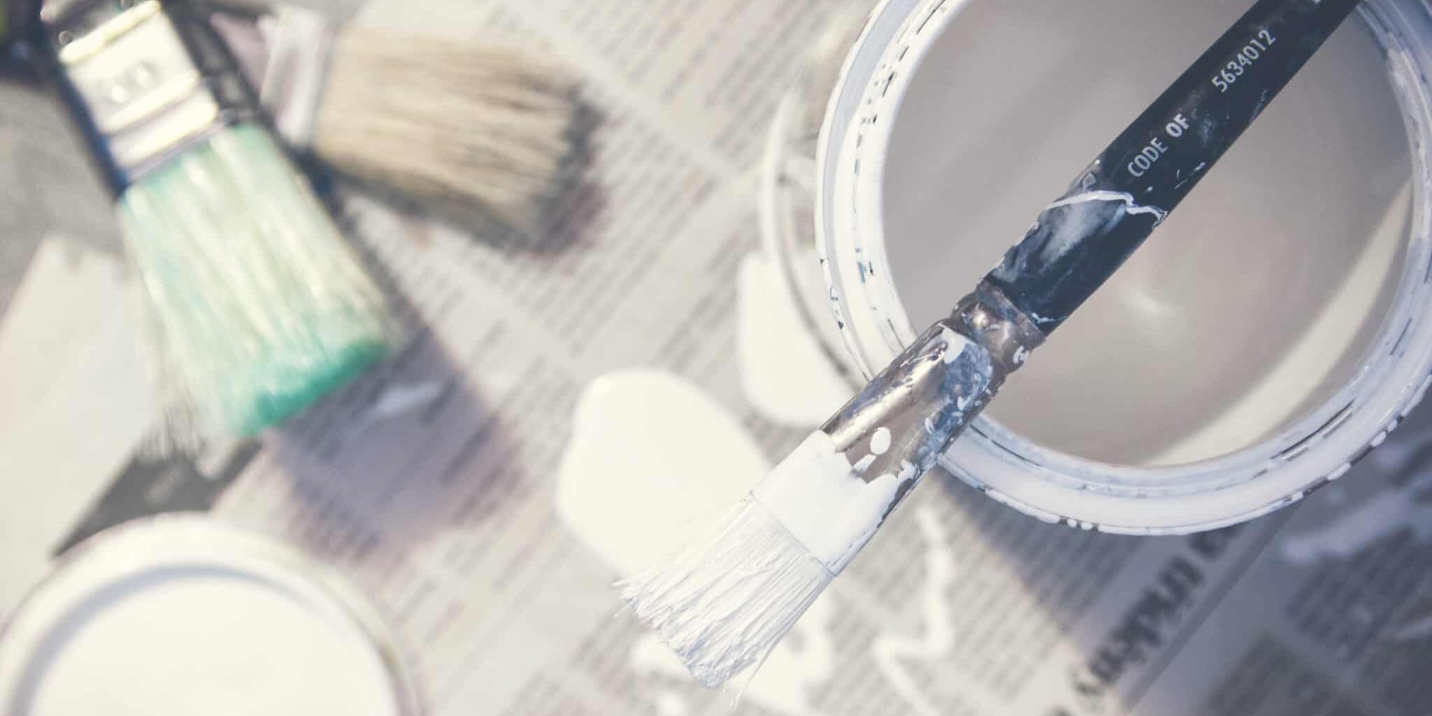 white paint bucket and paint brush