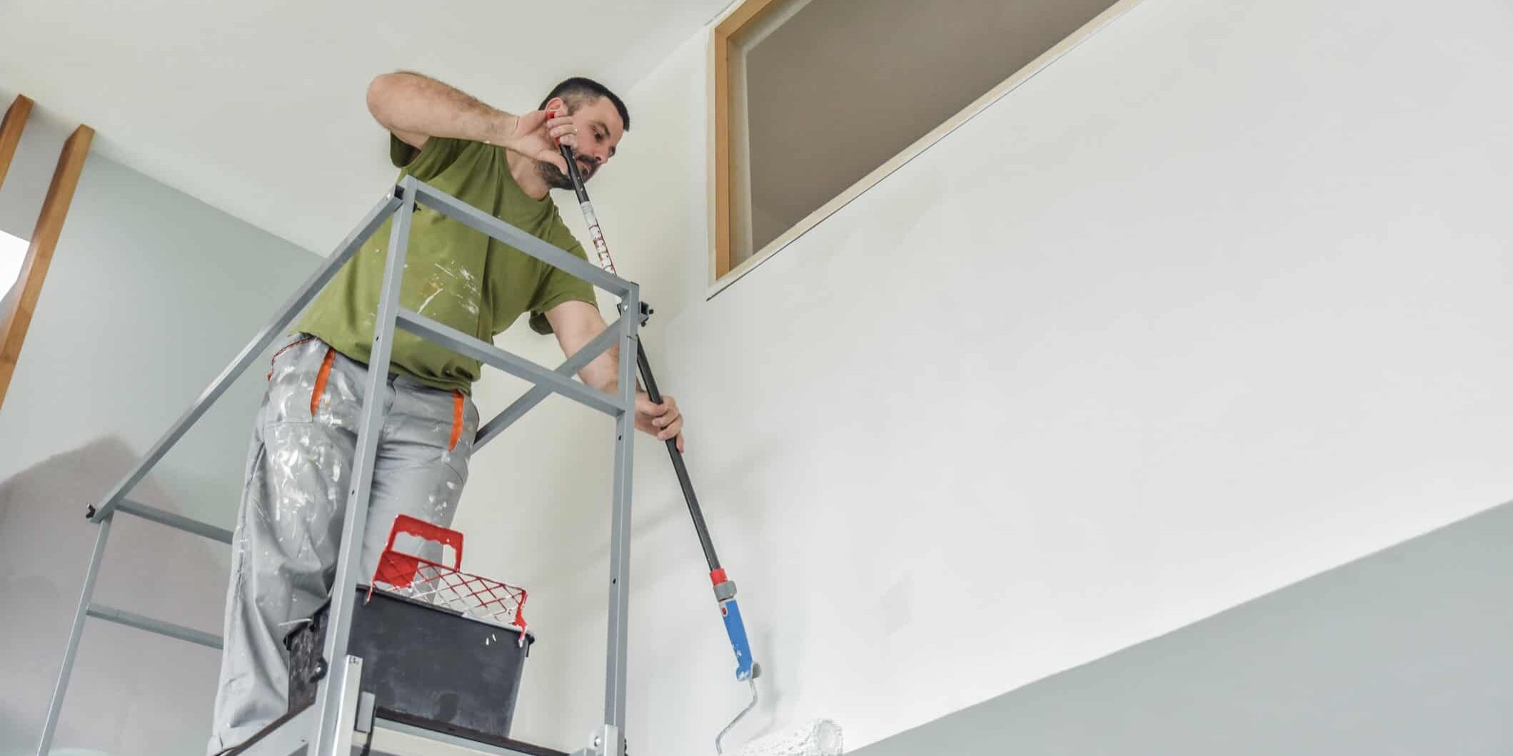 man climbed ladder to paint pressure treated wood-